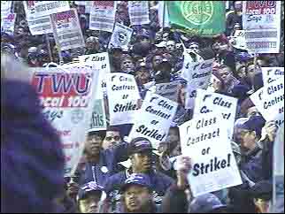 [photo of Oct. 30th Local 100 rally with 'First Class Contract or Strike!' placards]